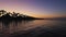 Tropical beach at sunset. Romantic night, glowing lights over the sea water