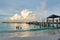 Tropical beach with tourists and pier