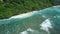 Tropical beach with vibrant ocean and waves in Bali. Aerial view