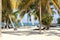 Tropical beach with white sand, palm trees and sailboats