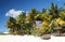 Tropical beach with white sand, palm trees and sun umbrellas