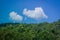 Tropical beautiful landscape view of misty rainforest mountain in cloudy day with blue sky in the background.