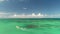 Tropical boats sailing on clear turquoise water of caribbean sea, aerial view