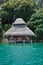 Tropical bungalow with thatched roof over water