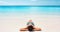 Tropical Caribbean beach vacation - suntan relaxation woman. Bikini girl lying down relaxing on white sand exotic