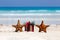 Tropical celebration on beach, two starfishes and present box