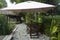 Tropical Christmas spotlights and table and chairs between bamboos and rush plant in exclusive luxury garden outside in Mexico