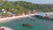 Tropical coast with traditional colorful houses surrounded by white beach and palm trees in Koh Rong, Cambodia