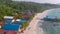 Tropical coast with traditional colorful houses surrounded by white beach and palm trees in Koh Rong, Cambodia