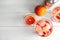 Tropical cocktail with ice cubes in glasses, fruit and shaker on wooden background, flat lay.