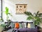 Tropical cozy living room with numerous houseplants and vintage insect poster on the wall