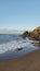 Tropical early morning sunrise on the beach with frothy waves, smooth sand and volcanic rocks