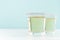 Tropical fresh alcohol yellow drink - golden tequila in two shot glasses with rim of salt in elegant pastel green color kitchen.