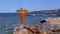 Tropical fresh juice in a glass with straw on the beach of Egypt stands on a rock by the sea