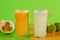 Tropical fruit juices on green background. Lemonade and passion fruit juice with fruits in the background