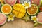 Tropical fruits mango, tangerine, guava, dragon fruit, star fruit, sapodilla with flowers of plumeria on the wooden background.