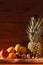 Tropical fruits and nuts vegan diet. Pineapple, grapefruit, orange, pear, walnuts on wooden background,weight loss foods