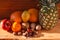 Tropical fruits and nuts vegan diet. Pineapple, grapefruit, orange, pear, walnuts on wooden background,weight loss foods