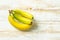 Tropical fruits ripe yellow greenish bananas on white planked wood table. Healthy diet vitamins breakfast fiber source concept.