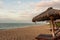 Tropical golden beach with yellow sand and turquoise sea with sunlight and waves and umbrellas and beach chairs and people