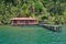 Tropical home over water with dock and lush shore