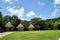 Tropical huts on an island with conical thatch roofs, weaved out of coconut palm tree fronds. Bright daylight, blue sky with puffy