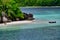 Tropical island with boat, Therese Island, Mahe, Seychelles. Horizontal view.