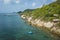 Tropical island coastline, Coast of Koh Tao island with turquoise clear water, boat and people snorkeling, bungalows with sea view