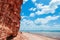 Tropical island red cliff  rock beach with blue sky and clouds in summer, tranquil serene ocean scenery. Fang Daeng in Prachuap