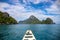 Tropical island and sea landscape. White wooden boat deck on still seascape. Green islands view