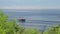 Tropical island seashore and a yacht with two masts, floating among sparkling waves