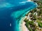 Tropical island with village, beach and turquoise crystal ocean, aerial view. Gili islands