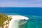 Tropical island of white sand with coconut trees. Boat with tourists on a beautiful beach, aerial view