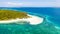 Tropical island of white sand with coconut trees. Boat with tourists on a beautiful beach, aerial view