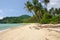 Tropical landscape with deserted amber sand beach, coconut palm trees and turquoise tropical sea on Koh Chang Island in Thailand