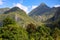 Tropical landscape with greenery and mountains in sunny day. Tropical nature view with green forest and huge peak