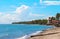 Tropical landscape with sea, beach and palm tree. Sand beach view with palms and house.