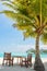 Tropical lunch spot with table and chairs at the beach