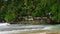 Tropical Mirissa beach lagoon, Sri Lanka, waves crash against rocks lush palm trees surround cabanas, secluded paradise