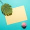 Tropical palm leaf with cupcake on bright blue background. Minimal summer composition. Flat lay