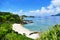 Tropical paradise of a pristine white beach, greenery, turquoise sea and deep blue sunny sky at Zamami, Okinawa, Japan