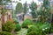 Tropical rain in the yard with green bushes and a motorcycle under a canopy