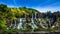 Tropical rainforest landscape panorama with flowing Pongour waterfall under blue sky. Da Lat, Vietnam