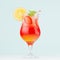 Tropical refreshing striped fruit drink sunrise with slices oranges, ice, strawberry, mint in wineglass on pastel green interior.