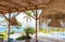 Tropical resort with pool and straw hut. Holiday villa with comfortable patio and indian ocean on background. Empty exotic resort.