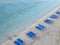 Tropical sand beach with blue empty deckchair