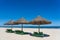 Tropical sand beach and summer sea water with blue sky and straw umbrella. Travel and nature concept