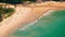 Tropical sandy beach landscape from high view point. Beautiful turquoise ocean and people relaxing in waves. Phuket, Thailand