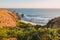 Tropical sandy beach with ocean and rocky cape in island