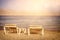 tropical sea beach and two chaise lounger at sunset light. Summer travel and vacation concept